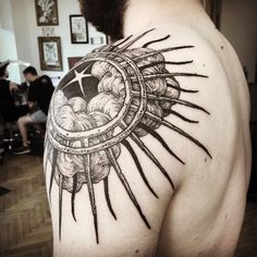 the back of a man's upper half sleeve with sun and clouds on it