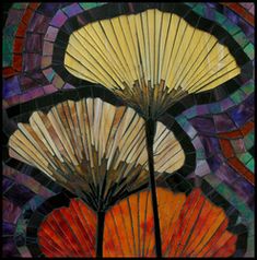 three colorful fan shaped objects in front of a stained glass window with purple, orange and yellow colors