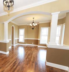 an empty living room with hard wood floors and white trim on the walls is pictured in this image