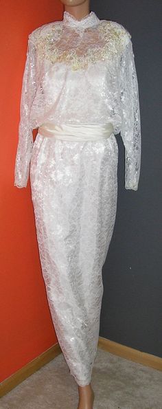 "Vintage, early 80s, victorian style, blouson, cream lace and taffeta, wedding, formal, gown, dress. Red union label. Bat wing sleeves. Sized 9/10. Outer shell 50% rayon, 50% poly. Lining 100% acetate. Waist and long drop in the back are taffeta, as is the lining. Open back. Removable shoulder pads. The beading is removable, the beaded shoulder \"fringe\" can be cut off as well. Excellent condition, no flaws or damage. Measurements: shoulders across front: 18\" chest across front: 18\" waist acr Long Sleeve Lace Dress With Lace Collar For Wedding, Elegant Lace Victorian Wedding Dress, Fitted Victorian Dress With Lace Sleeves For Wedding, White Vintage Victorian Dress For Party, White Victorian Dress For Party, Elegant Fitted Lace For Vintage Events, Fitted Lace Dress With Lace Collar For Wedding, Victorian Lace Dress With Lace Sleeves For Wedding, Formal Victorian Dress With Lace Collar