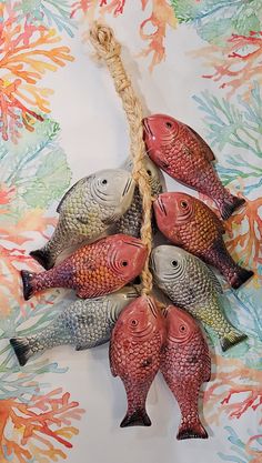 five fish hanging from a rope on a wall