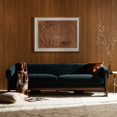 a living room with wood paneling and a blue couch next to a coffee table