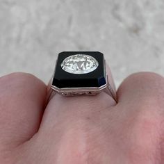 This antique ring centers an old European cut diamond bezel-set in buffed onyx. The center diamond weighs approximately 2.25 carats, M color and VS2 clarity. The onyx is held by prongs which lead to an openwork under-gallery. This ring was handcrafted in platinum during the Art Deco era, circa 1920.
The measurements of the center diamond are approximately 7.94mm x 7.95mm x 4.99mm. The approximate measurements of this ring including the onyx halo are 16.19mm x 13.00mm.
This ring can be resized to 1920s Jewelry, Estate Diamond Jewelry, Art Deco 1920s, Antique Ring, Art Deco Era, European Cut Diamonds, Perfect Engagement Ring, Antique Art Deco, Bezel Diamond