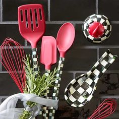 kitchen utensils are placed next to a brick wall