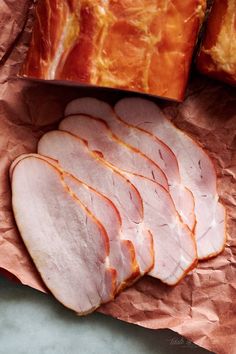 slices of ham sitting on top of brown paper