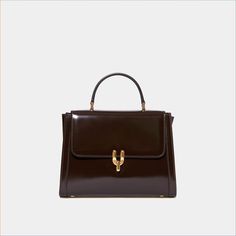 Dimensions : 23x17x6cm / 9x6.6x2.3inch50's inspired glossy calfskin bag with brass Diapason clasp. Created in collaboration with Laurence Fortin-Côté, this bag is inspired by her chic and vintage style. Can be carried by hand or on the shoulder with its adjustable leather shoulder strap. Made in Italy. My Style Bags, Timeless Chic, Purse Brands, Fancy Bags, Pretty Bags, Best Sneakers, Cute Bags, Suitcases, Small Leather Goods