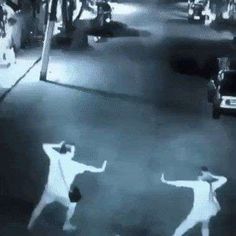 two people are dancing in the street at night