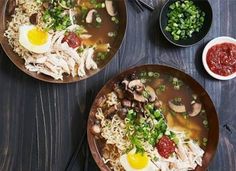 two brown bowls filled with food on top of a wooden table