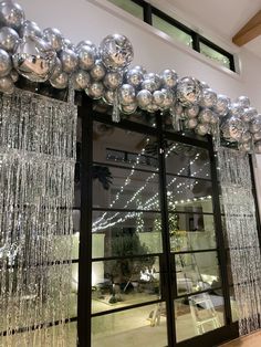 an entrance to a building decorated with silver balls and streamers