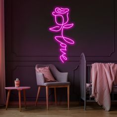 a pink neon sign that says love on the wall next to a baby's crib