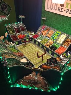 a football themed buffet with lights on the sides and snacks in trays at each end