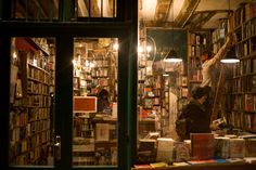 a man standing in front of a book store filled with books