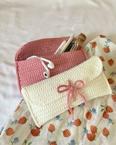 two crocheted purses sitting on top of a bed