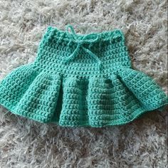 a crocheted skirt is laying on the carpet