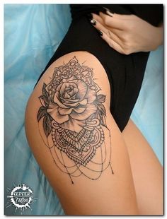 a woman's thigh with a rose tattoo on the side and an intricate design