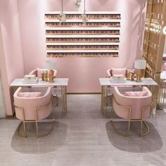 a nail salon with pink chairs and gold accents