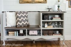 a shelf with books and pillows on top of it in front of a wall mounted mirror