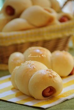 hot dogs in buns with mustard and ketchup on a yellow striped napkin