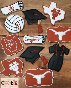 decorated cookies are arranged on a table with graduation caps, mitts and other items