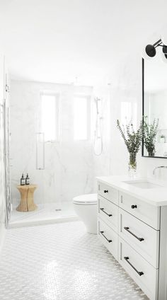 a white bathroom with black and white accessories