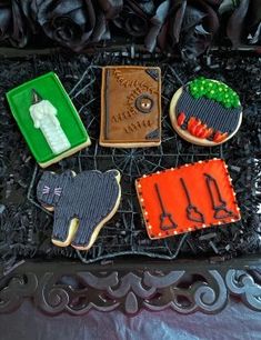 decorated cookies in the shape of animals on a black tray with flowers and other decorations