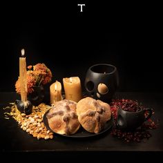 a table topped with cookies and candles on top of a black plate next to flowers