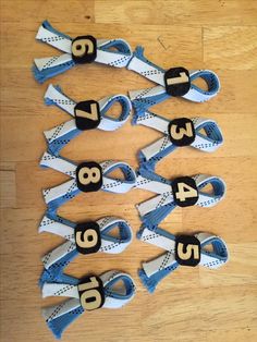 several pairs of blue and white shoes with numbers on them sitting on a wooden floor