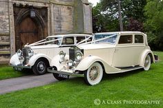 two antique cars parked in front of an old building