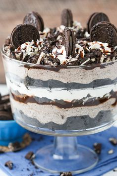 an oreo cookies and cream trifle is shown in a glass dish on a blue napkin