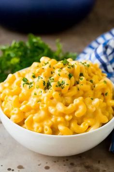 a white bowl filled with macaroni and cheese on top of a blue towel