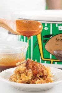 a close up of a plate of food near an ice cream container with a spoon