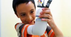 a young boy holding up an electronic device