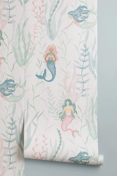 a wallpaper with mermaids and seaweed on the side, in pastel colors