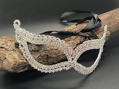 Introducing our enchanting Eye Mask, the epitome of elegance and mystery. Crafted with exquisite attention to detail, this eye-catching accessory is designed to captivate and mesmerize. Constructed from high-quality alloy metal adorned with delicate leaf-shaped rhinestones, each facet of this mask exudes sophistication and charm. Measuring approximately 7 inches by 2.3 inches (16 x 5.5cm), it offers a perfect balance of size and intricacy. Elevate your ensemble and ignite intrigue with this mask, as its graceful design adds an air of mystique to any occasion. Whether you're attending a wedding party, a masquerade ball, a costume gala, or celebrating during Mardi Gras, this mask is the ideal choice to add a touch of allure and allure to your look. With its black ribbon tie, it ensures a sec Fantasy Silver Masquerade Mask For Mardi Gras, Luxury Silver Masks For Masquerade, Silver Eye Mask For Carnival Masquerade, Silver Mardi Gras Eye Mask, Carnival Rhinestone Eye Mask, Ball Dance, Masquerade Ball Mask, Ball Mask, Mask Masquerade