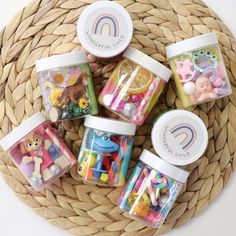 small jars filled with different types of candies and candy in front of a wicker basket