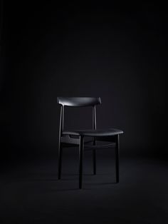 a black chair sitting on top of a dark floor