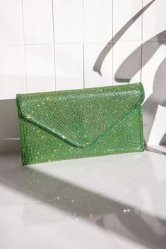 Not to be dramatic, but everyone needs this clutch! The Quentin Green Rhinestone Envelope Purse features a green rhinestone and vegan leather fabric, a green satin lining, a green vegan leather back, a silver detachable shoulder chain, a snap button closure, and an inside card holder. Lined.;  Purse measures 9" wide, 5" tall, and 1" deep;  Man made materials.; Elegant Green Bag For Night Out, Green Rhinestone Clutch Evening Bag, Glamorous Green Evening Bag, Glamorous Green Rectangular Clutch, Green Rhinestone Party Evening Bag, Elegant Green Envelope Clutch, Envelope Purse, Shoulder Chain, Green Satin