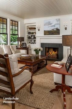 a living room filled with furniture and a fire place in the middle of a room