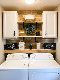 a washer and dryer in a small room with white cupboards on the wall