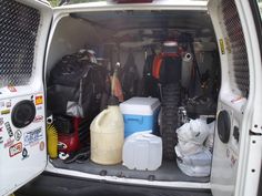 the back end of a white van filled with various items