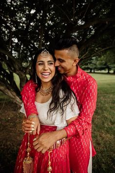 a man and woman hugging under a tree