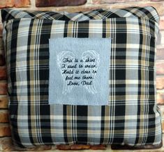 a black and white plaid pillow with an embroidered angel on it that says,'this is