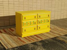 a yellow dresser sitting on top of a rug