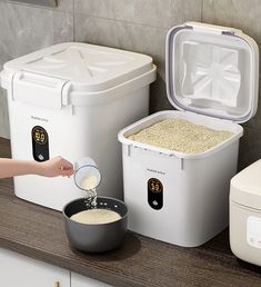 a person is pouring something into a bowl next to two coolers on a counter