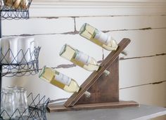 several bottles of wine sitting on top of a wooden stand in front of a brick wall