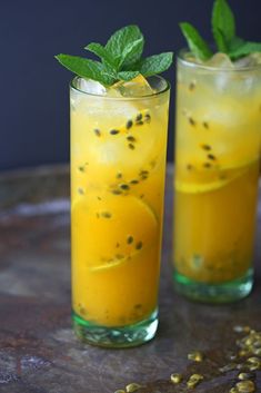 two glasses filled with drinks sitting on top of a table