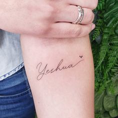 a woman's arm with the word yesha on it and a small heart