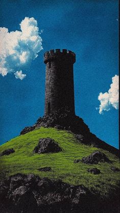 a tall tower sitting on top of a lush green hill under a blue cloudy sky