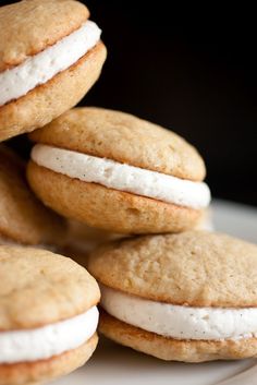 a pile of cookies sitting on top of a white plate covered in frosted cream