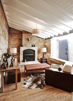 a living room filled with furniture and a fire place in the middle of a room